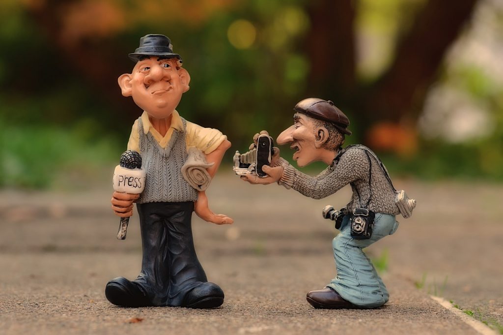 Periodista y fotógrafo representados con figuras