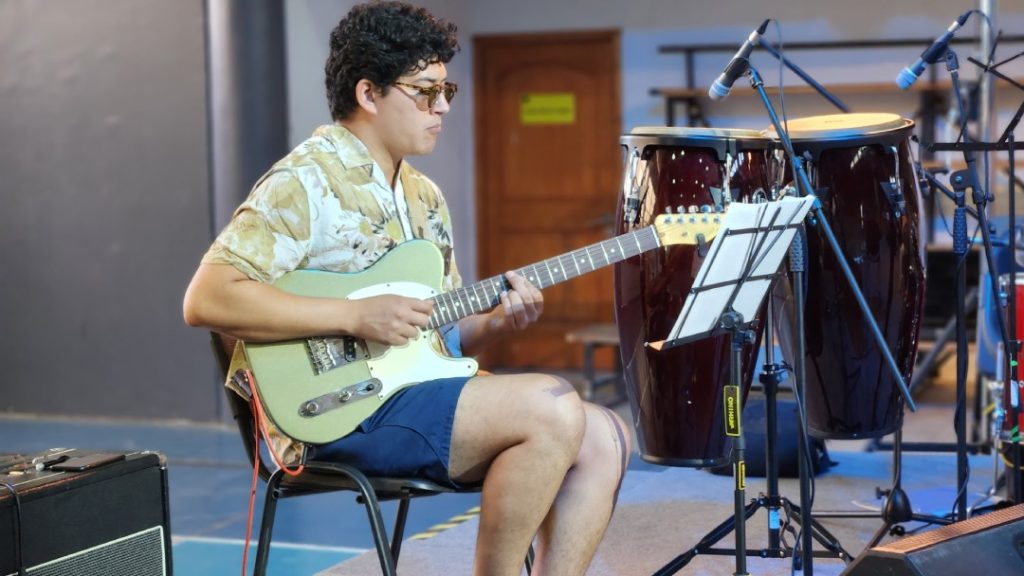 Guitarrista parte de la orquesta que acompañará a los estudiantes que presentan en Taller Final de Composición Musical