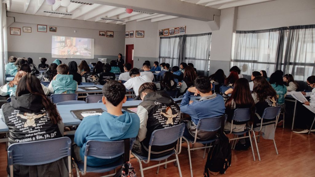 Sala de clases con estudiantes mirando una proyección con las carreras de I.P. ARCOS