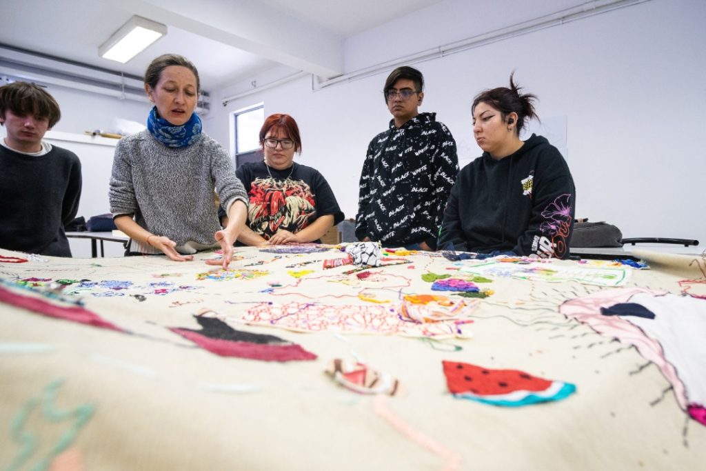 Docente Fran Robles junto a estudiantes de Ilustración trabajando en el proyecto tapiz viajero
