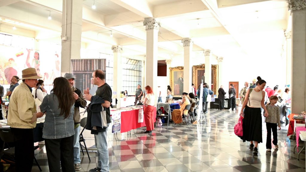 Interior del edificio consistorial de Valparaíso. Personas mirando stands de libros