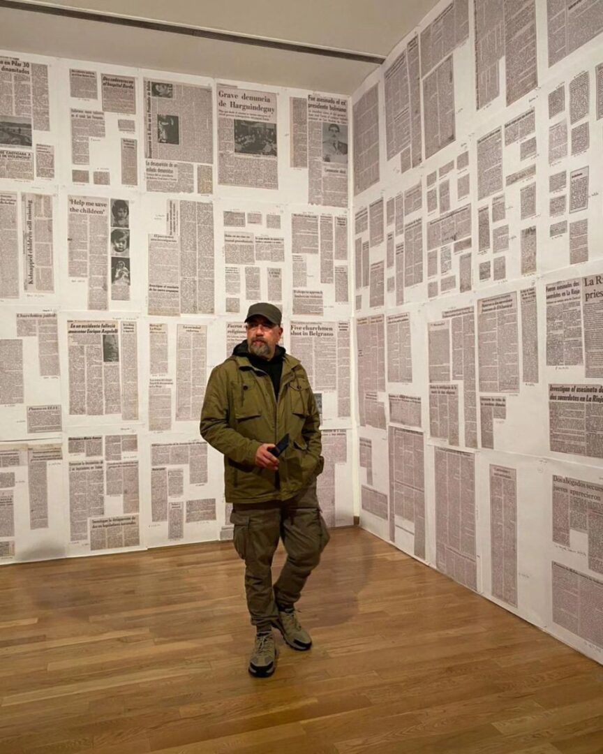 Víctor Hugo Bravo, docente de ARCOS, en una sala repleta de recortes de diarios